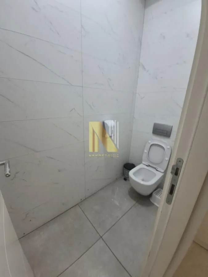 Smaller bathroom lined with ceramic tiles and equipped with a toilet.