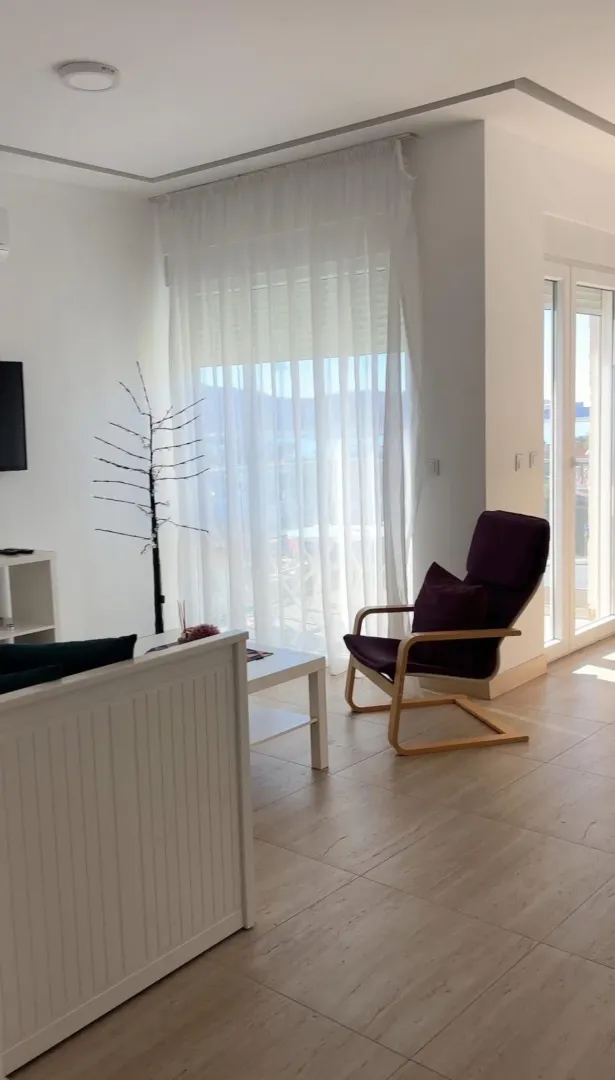 Bright living room with an armchair and a large window.