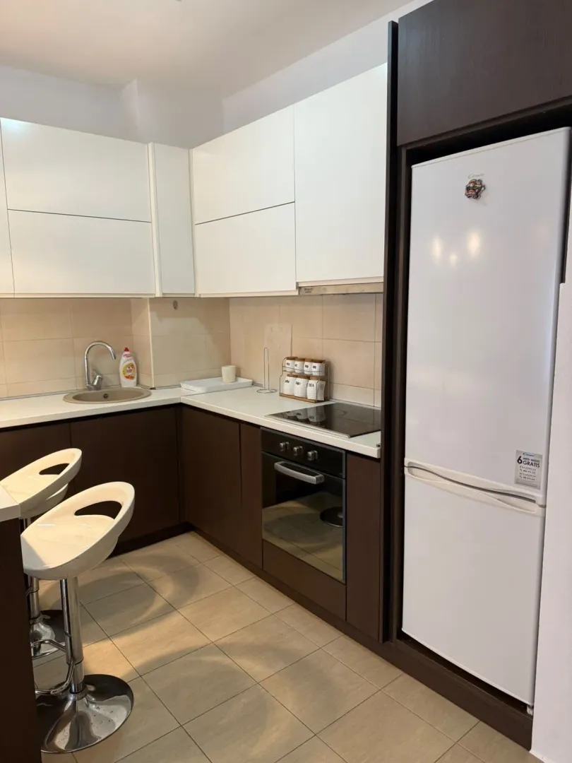 Modern kitchen with white and dark cabinetry and a breakfast bar.