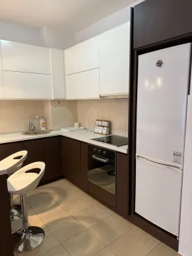 Modern kitchen with white and dark cabinetry and a breakfast bar. - image 3