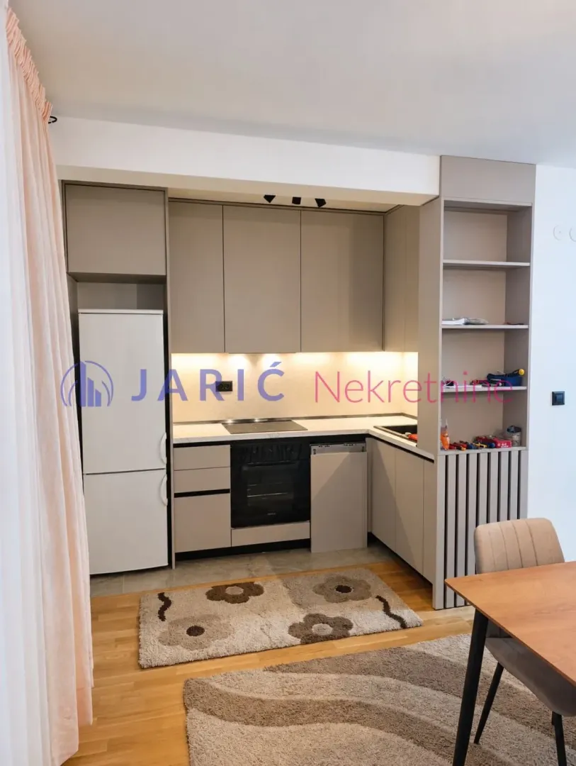 Modern kitchen with beige units and built-in appliances.