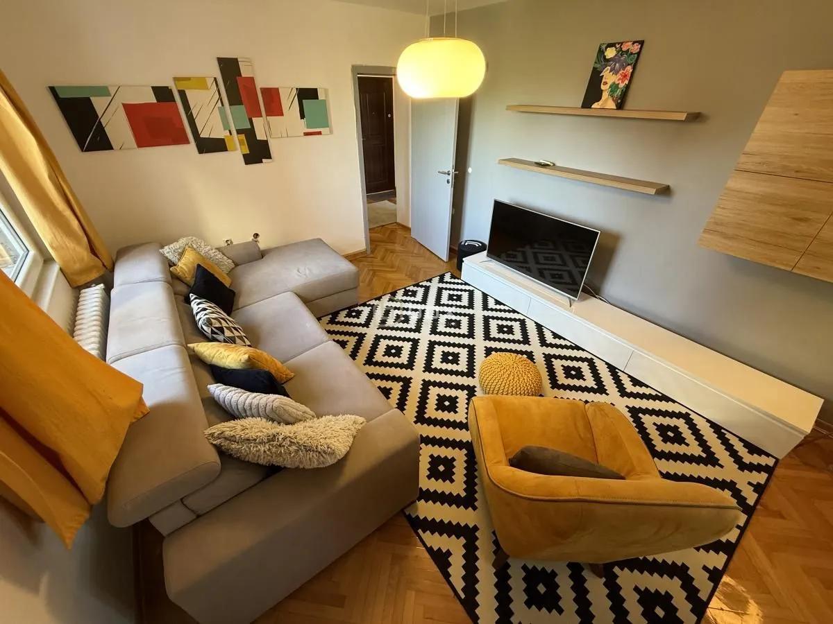 Living room with a sectional sofa, armchair, and TV.