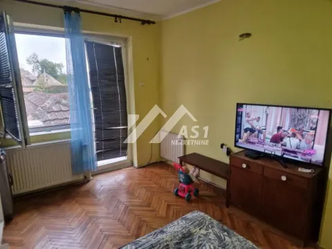 Manja spavaća soba sa TV-om, drvenim parketom i izlazom na balkon. - image 3