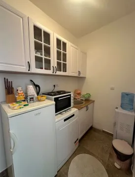 Manja bijela kuhinja sa elementima, frižiderom i kućnim aparatima. - image 5
