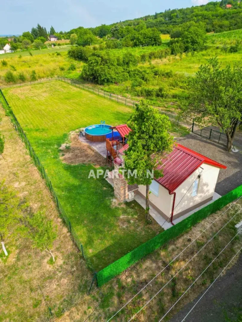 Pogled iz vazduha na kuću sa dvorištem, bazenom i zelenom površinom.