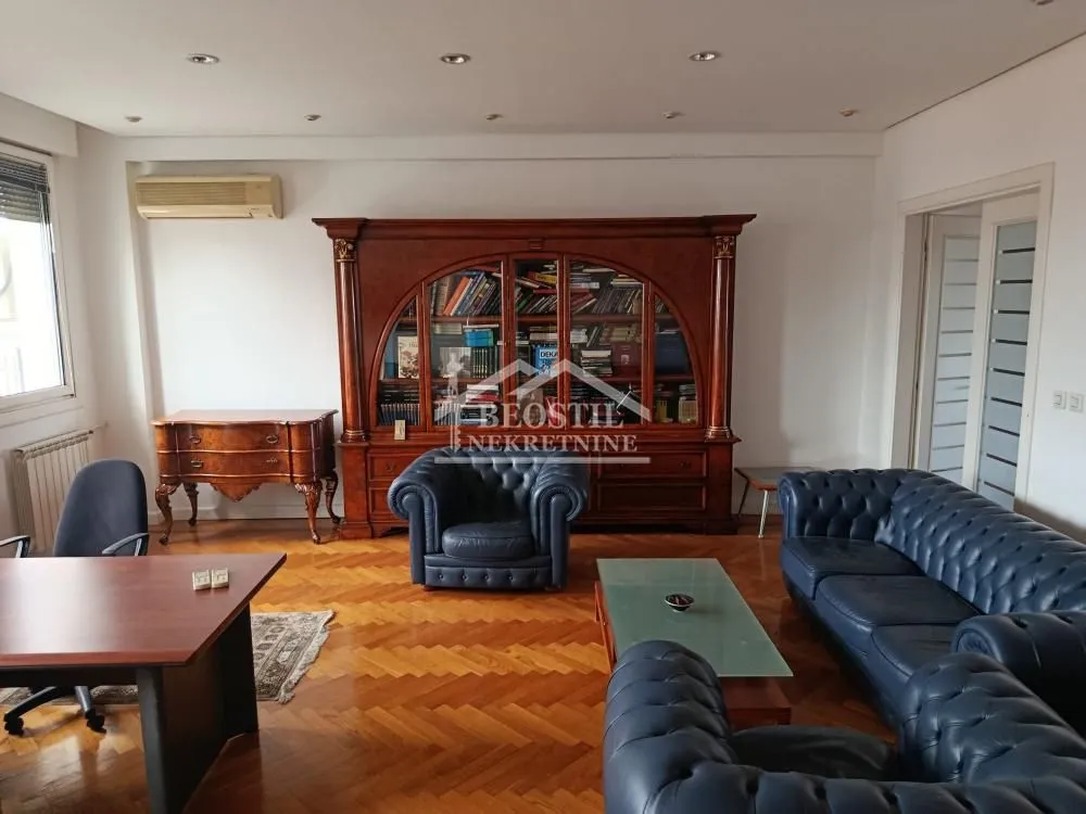 Living room with sofa set, desk, and a large wooden display cabinet.