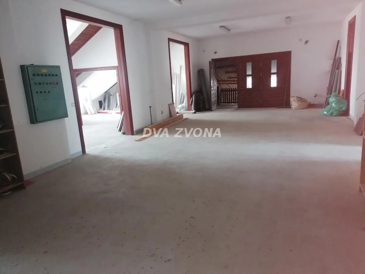 Empty room in a house with a concrete floor and wooden doors.