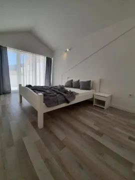 Prostrana spavaća soba sa bračnim krevetom i drvenim podom. - image 19