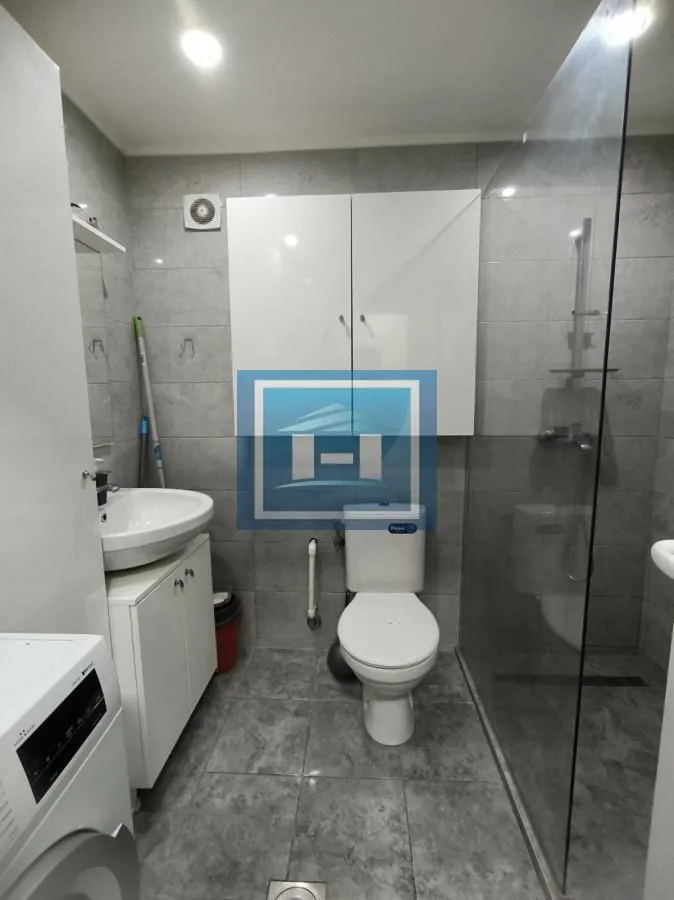 Moderno kupatilo sa tuš kabinom, umivaonikom i wc šoljom.