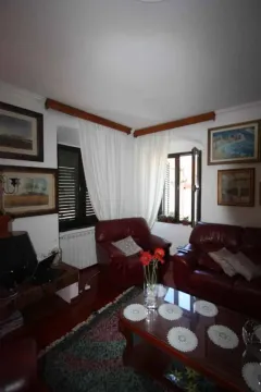 Dnevni boravak sa kožnim garniturama, stočićem i slikama na zidu. - image 7