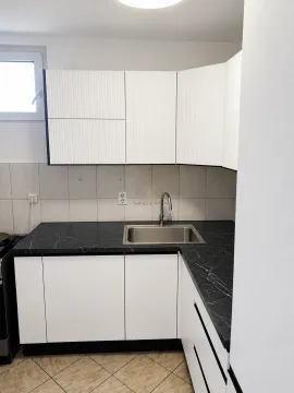 Kuhinja sa bijelim elementima, tamnom radnom pločom i sudoperom. - image 5