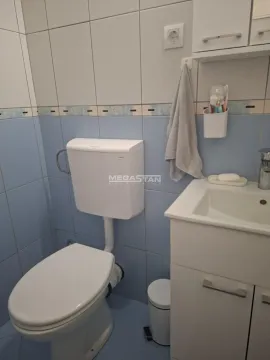 Manje kupatilo sa pločicama, wc šoljom i umivaonikom sa ormarićem. - image 5