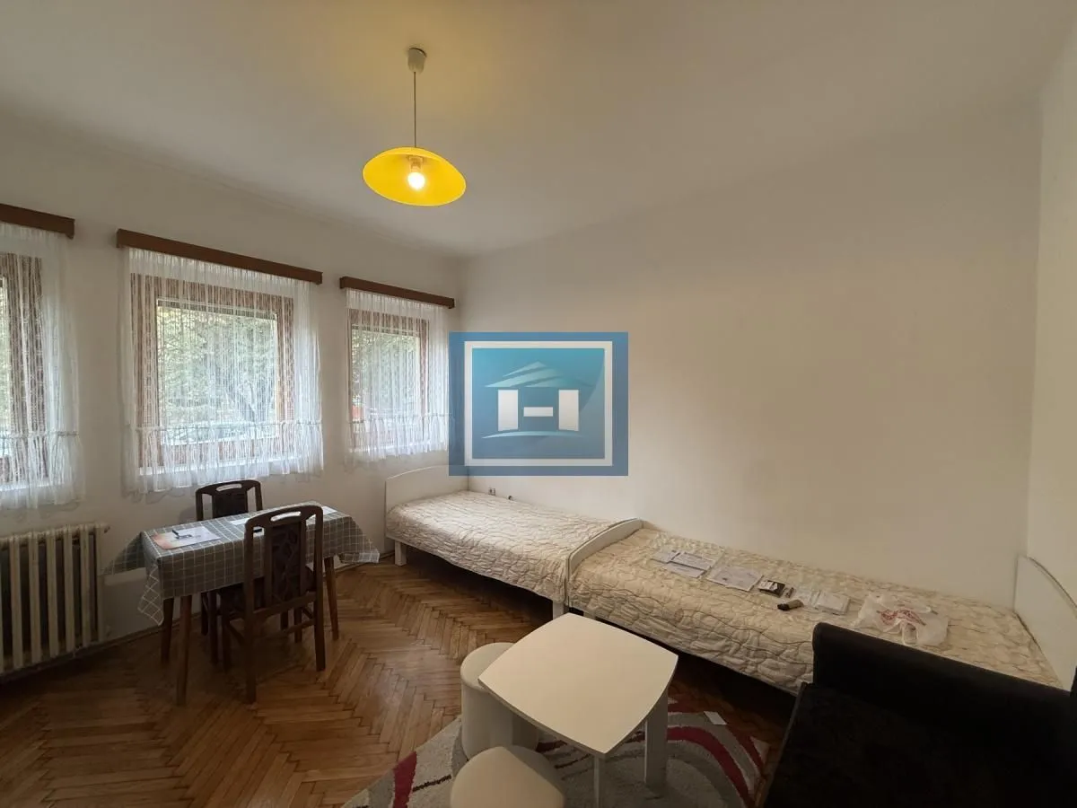 Furnished bedroom with beds and a dining table.