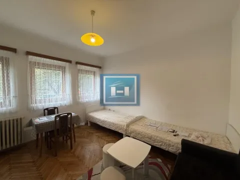 Furnished bedroom with beds and a dining table. - image 3