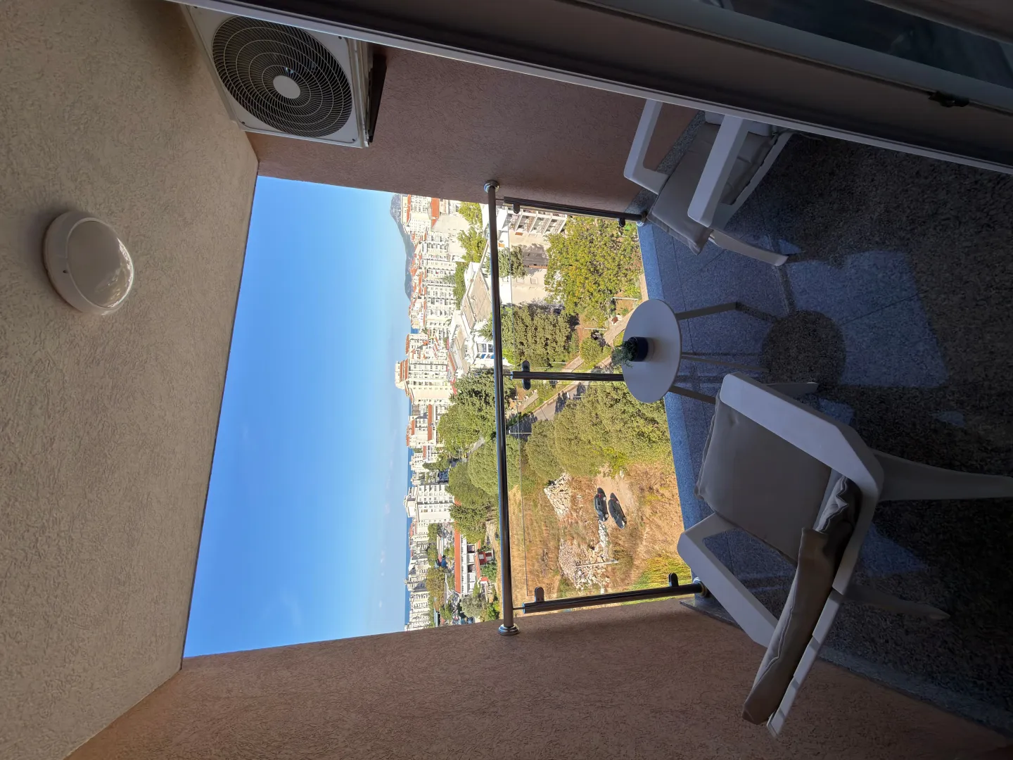 Furnished balcony with outdoor seating and a city view.
