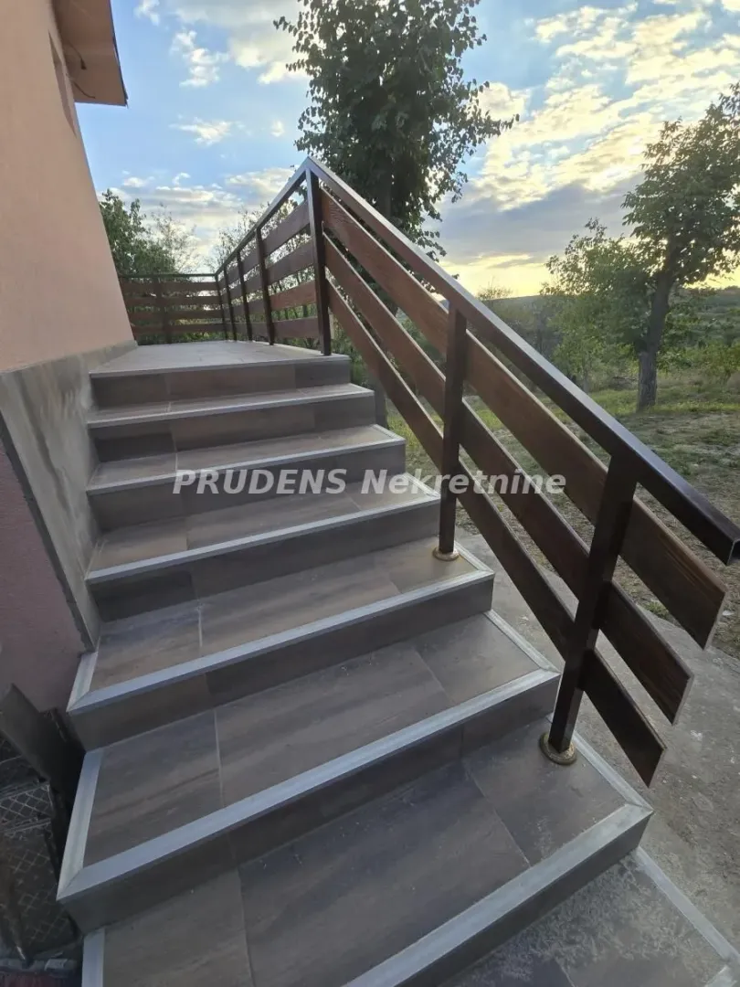 External stairs with a wooden railing and ceramic tiles.