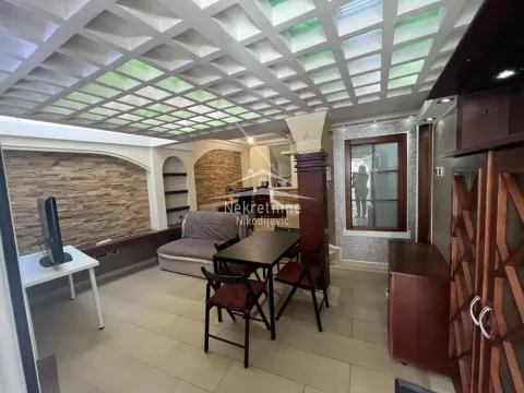 Dnevna soba sa garniturom za sedenje, trpezarijskim stolom i specifičnim plafonom. - image 2