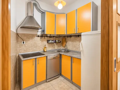 Small kitchen with yellow cabinets and built-in appliances. - image 4