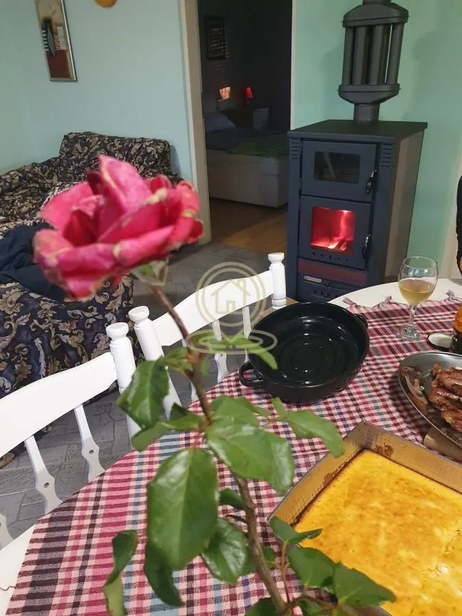 Dnevna soba sa trpezarijskim stolom i peći na drva.
