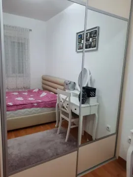 Furnished bedroom with a double bed, a desk, and a large wardrobe. - image 5
