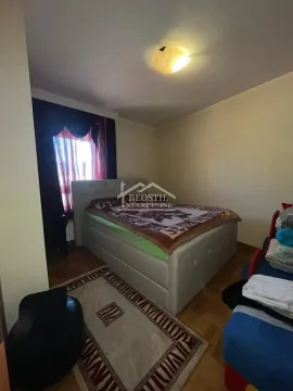 Spavaća soba sa bračnim krevetom, prozorom sa tamnim zavesama i tepihom na podu. - image 8