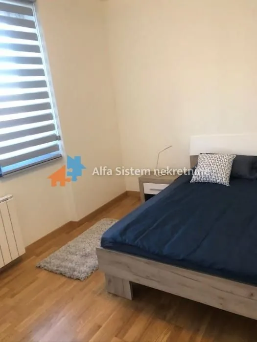 Furnished bedroom with a double bed and a window.