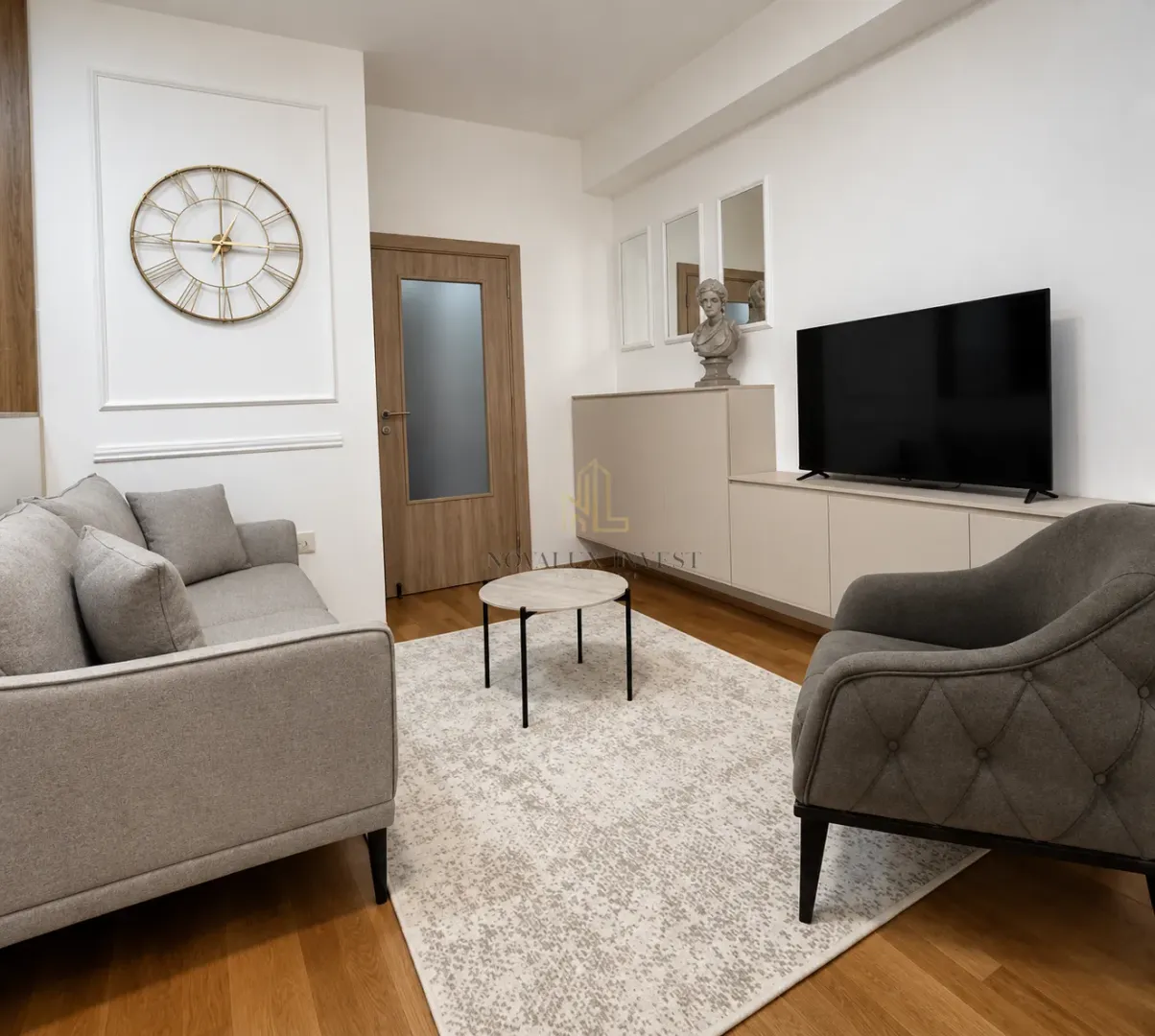 Dnevna soba sa garniturom, stočićem i televizorom.