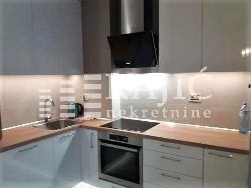 Modern kitchen with built-in appliances and lighting.