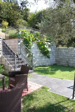 Uređeno dvorište sa kamenim zidovima, stepeništem i garniturom za sjedenje. - image 6