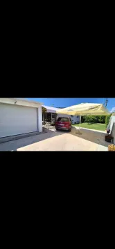 Dvorište sa garažom, automobilom i suncobranom ispred kuće. - image 2