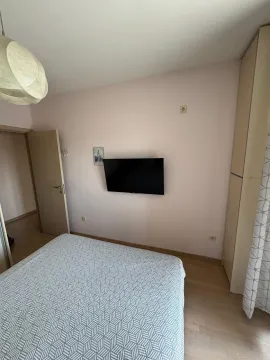 Pogled na spavaću sobu sa krevetom i televizorom na zidu. - image 18