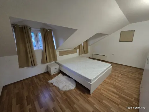Potkrovna spavaća soba sa bračnim krevetom, drvenim podom i prozorima. - image 7