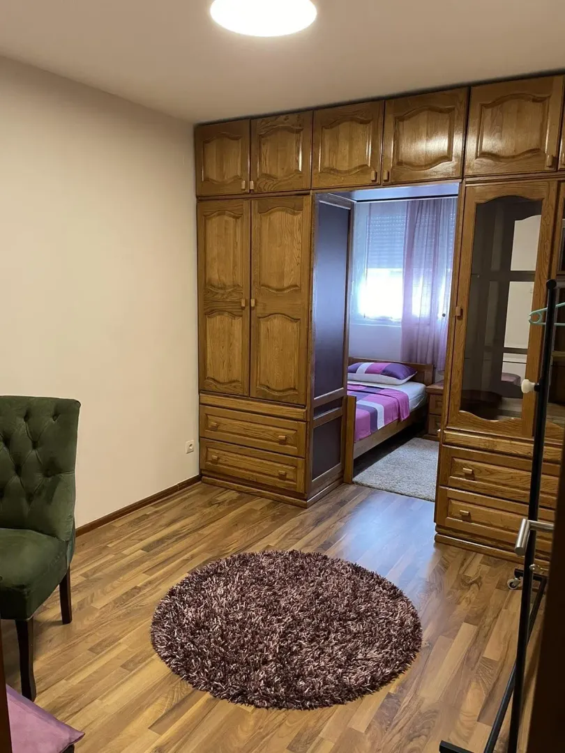 Bright bedroom featuring a large wooden wardrobe and laminate flooring.