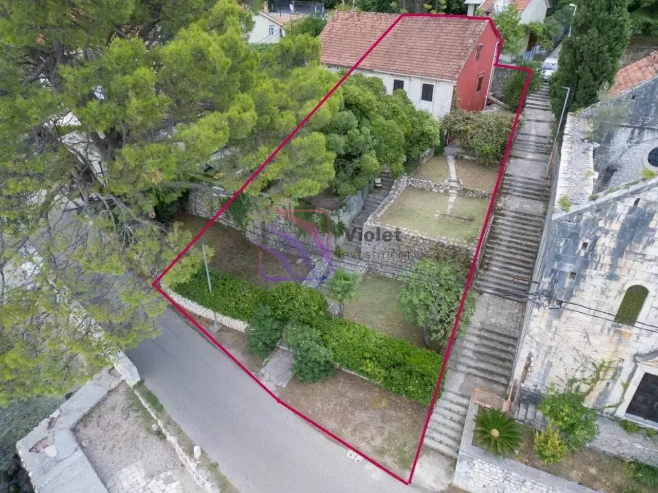 Pogled iz vazduha na imanje sa kućom i uređenim dvorištem.