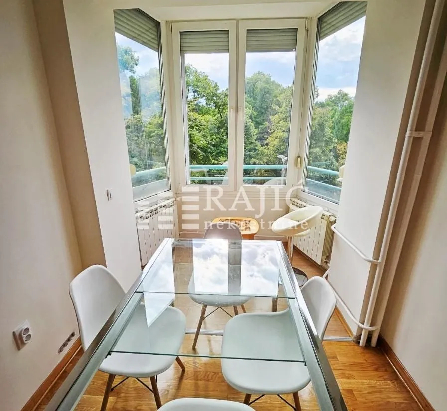 Dining area with a glass table and green views.