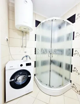 Bathroom with a shower cabin, water heater and washing machine. - image 11