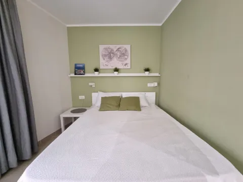 Furnished bedroom with a double bed and a wall shelf. - image 6