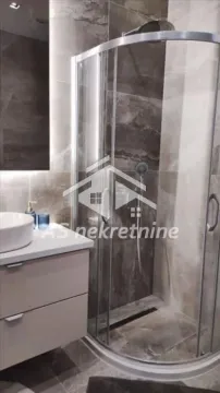 Modern bathroom equipped with a shower cabin and a sink. - image 18