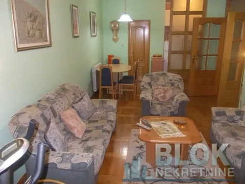 Living room with sofa, coffee table, and a dining area in the background. - image 10