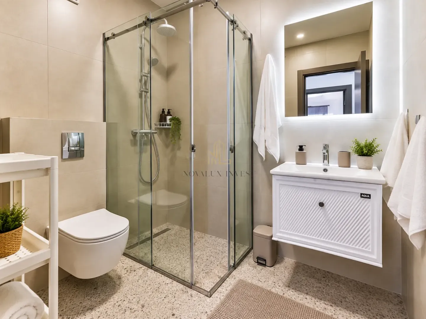 Modernly equipped bathroom with a shower cabin and washbasin.