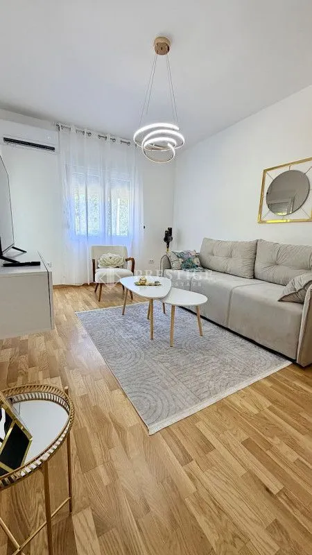 Dnevna soba sa garniturom, stočićem i modernim osvjetljenjem.