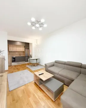 Spacious living room with a sofa set, dining area, and kitchen in the background. - image 3