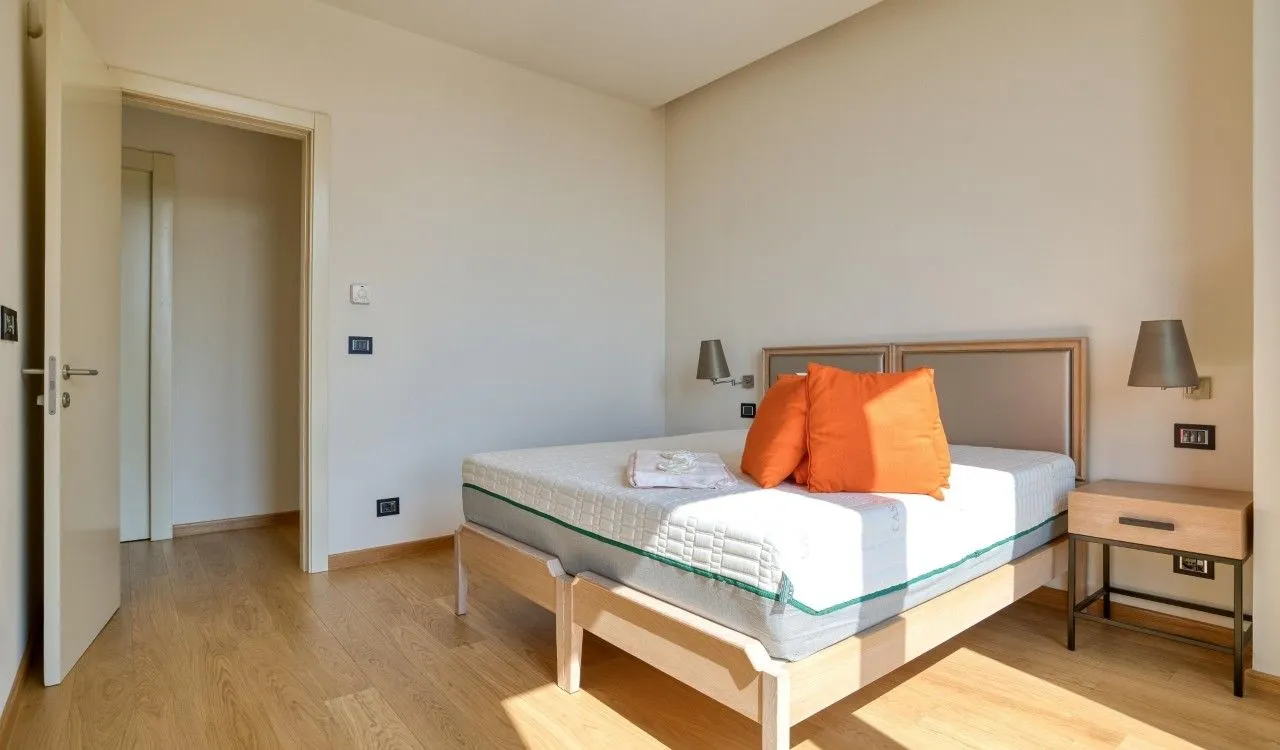 Bedroom with a double bed, nightstand, and wooden flooring.