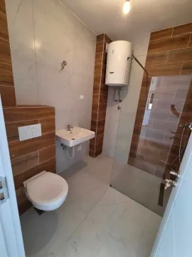 Moderno kupatilo sa tuš kabinom, konzolnom šoljom i umivaonikom. - image 6