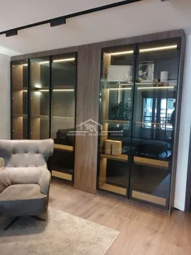 Dnevna soba sa velikim drvenim ormarom sa staklenim vratima i foteljom. - image 6
