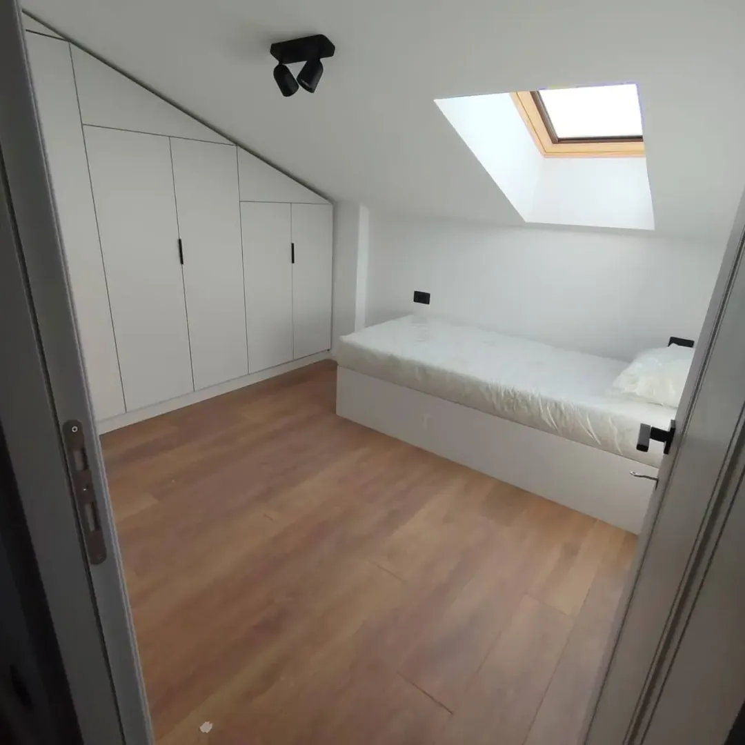 Small bedroom with a bed, built-in wardrobe, and a skylight.