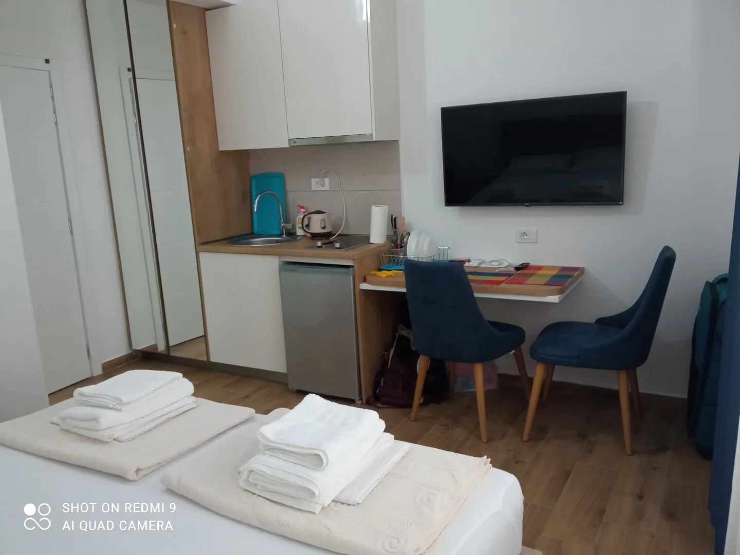 Small room with a bed, kitchenette, and dining table with chairs.