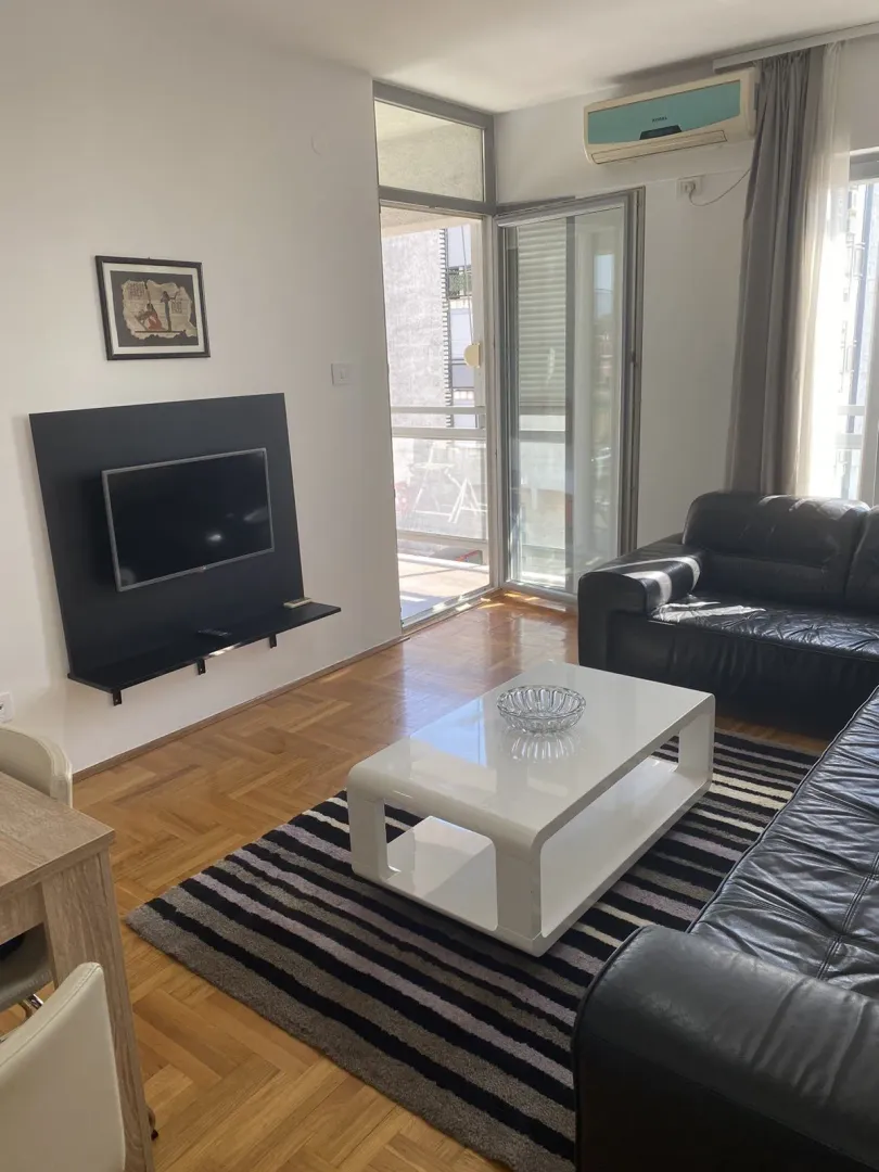 Bright living room with a leather sofa set and a TV.