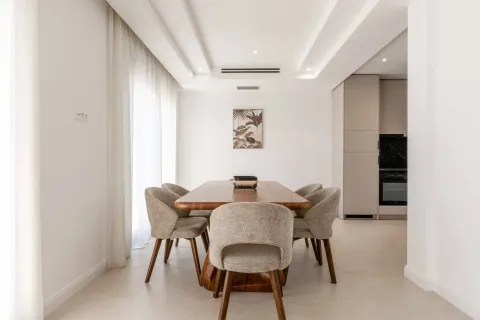 Dining area with a wooden table and upholstered chairs, connected to the kitchen. - image 23