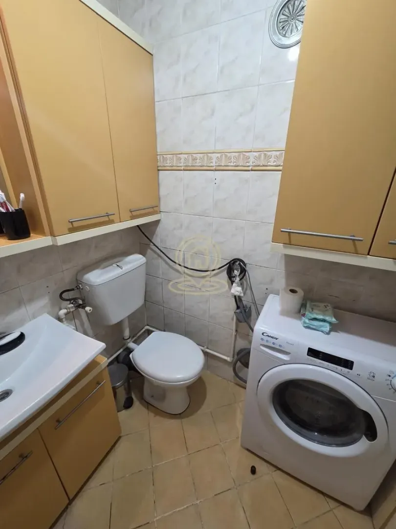 Kompaktno kupatilo sa umivaonikom, WC šoljom, ormarićima i veš mašinom.